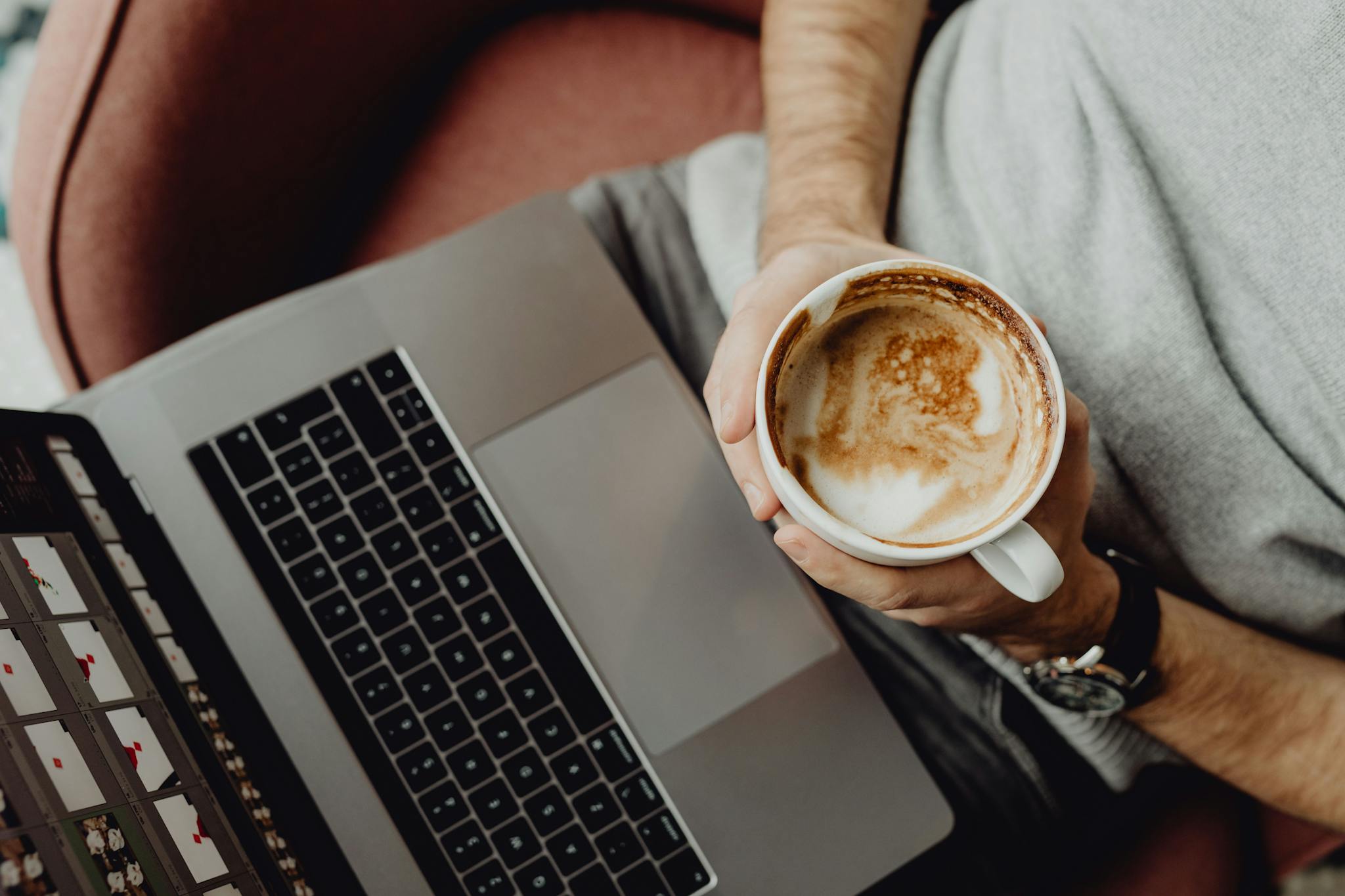 A person relaxing with a latte and laptop, top view on a comfortable chair. Perfect freelance vibe.